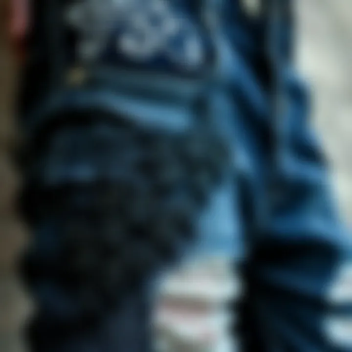 A close-up view of distressed goth jeans featuring intricate embroidery.